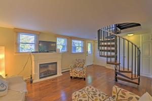 a living room with a staircase and a fireplace at Provincetown Vacation Rental with Patio! in Provincetown
