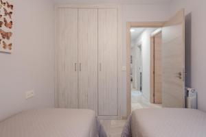 1 dormitorio con 2 camas y armario en Congresos Granada Apartment by A3Rentals, en Granada