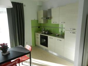 a kitchen with white cabinets and a table and a dining room at Pozzilli's Affitta in Pozzilli