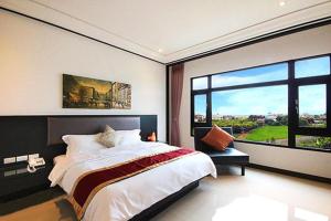 a bedroom with a large bed and a large window at Lo Hong ka Countryside House in Luodong