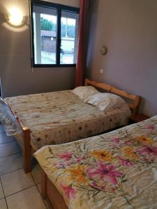 two beds in a room with a window at Auberge de l'Europe in Saint-Quentin-Fallavier