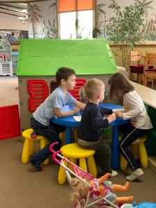 a group of children sitting at a table in a play room at Galian Hotel in Odesa