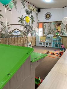 ein Kinderzimmer mit einer grünen Theke und ein Zimmer mit einem Bett in der Unterkunft Galian Hotel in Odessa