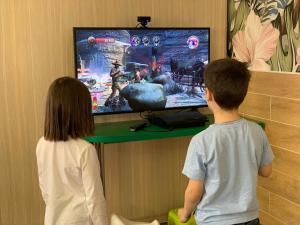 a boy and a girl playing a video game at Galian Hotel in Odesa