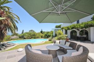 a patio with chairs and an umbrella and a pool at Montrose Guesthouse in Somerset West +53 photos