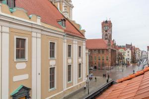 una calle de la ciudad con edificios y una torre del reloj en Rose Old Town Apartment, en Toruń