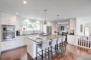 a kitchen with white cabinets and a island with bar stools at Beautiful Sonoma House with Patio and Vineyard Views! in Sonoma