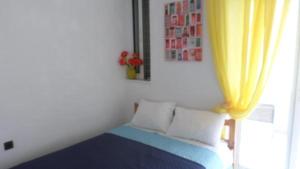 a room with a bed with a yellow curtain at Summer Holidays Studio in Chania