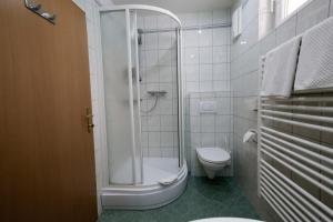 biała łazienka z prysznicem i toaletą w obiekcie Fischwirtshaus Landmotel Die Donaurast w mieście Persenbeug