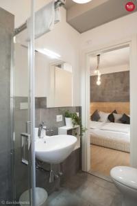 a bathroom with a sink and a bedroom with a bed at Sleep In Udine in Udine
