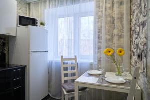 a kitchen with a white refrigerator and a table with chairs at "GOOD NIGHT" on Kotovskogo 28 in Tomsk