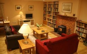 a living room with a red couch and a fireplace at Brewery Cottage, Chichester in Chichester