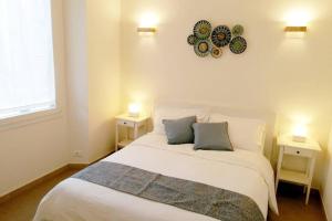 1 dormitorio con 1 cama blanca, 2 mesas y reloj en Modern Apartment 5 Minutes from Florence's Historic Center, en Florencia