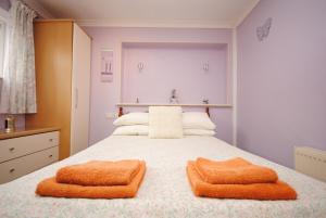 a bedroom with a bed with two towels on it at Cullimore, West Wittering in West Wittering