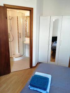 een slaapkamer met een douche en een blauw bed bij Bed and Breakfast Relax in Trento