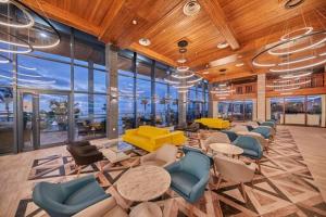 a large room with chairs and tables and windows at Sandos Papagayo in Playa Blanca