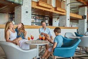 a family sitting at a table in a restaurant at Sandos Papagayo in Playa Blanca