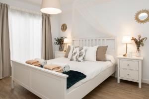 una camera da letto bianca con un grande letto bianco e una finestra di Flower Beach Suite 20 a Playa Honda Altre 14 foto