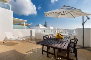 a patio with a table and an umbrella and chairs at Flower Beach Suite 20 in Playa Honda