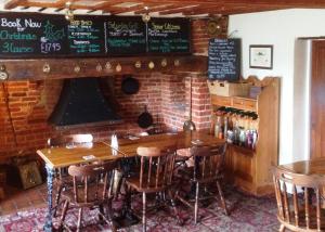 a bar with a wooden table and chairs and a brick wall at Stukeleys Hotel in Great Stukeley