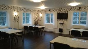 a room with tables and chairs and a flat screen tv at Gålö Havsbad - Holiday Cottages and Hostel in Gålö