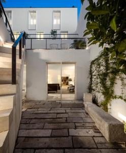 a house with white walls and a stone walkway at The Late Birds Lisbon - Gay Urban Resort in Lisbon