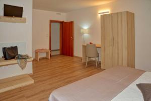 a bedroom with a bed and a desk with a television at Hotel Albània in Otranto
