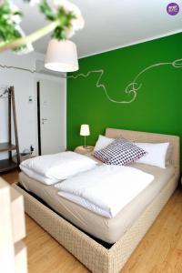 two beds in a room with a green wall at Stop & Sleep Udine in Udine