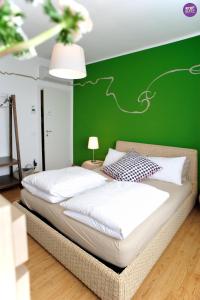 2 camas en una habitación con una pared verde en Stop & Sleep Udine, en Udine