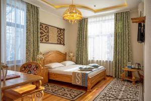 1 dormitorio con cama y lámpara de araña en Navat Hotel, en Bishkek