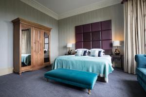 a bedroom with a bed with blue sheets and pillows at Nether Abbey Hotel in North Berwick