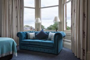 a blue couch in a room with a window at Nether Abbey Hotel in North Berwick