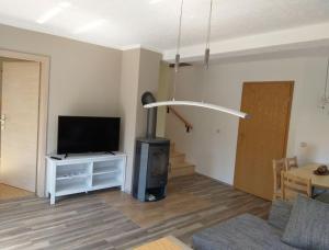 a living room with a flat screen tv and a living room with a table at Ferienappartment Henke in Hohnstein