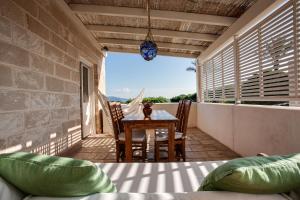 eine Terrasse mit einem Tisch und Stühlen auf dem Balkon in der Unterkunft Geco Resort in Favignana