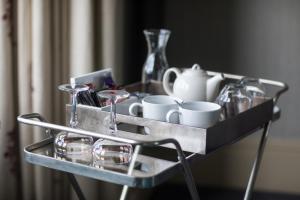 a metal tray with cups and glasses on a table at Nether Abbey Hotel in North Berwick