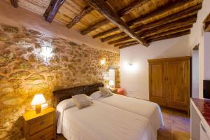 a bedroom with a bed and a stone wall at Agroturismo Xarc in Santa Eularia des Riu