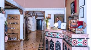 Een man aan een toonbank in een winkel. bij Amani Hotel Suites & Spa in Marrakesh