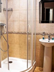 y baño con ducha y lavamanos. en Hotel Akvareli Vosstaniya, en San Petersburgo