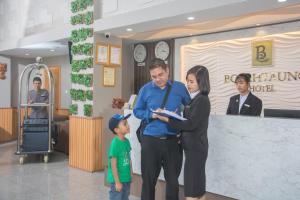 a man and a woman and a child standing in a lobby at Botahtaung Hotel in Yangon