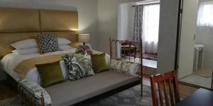 1 dormitorio con 1 cama con sofá y mesa en Green Venus, en Kaapsehoop