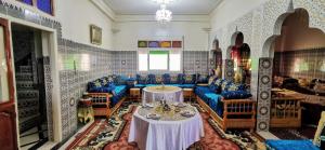 Gite El Menzeh في مولاي ادريس: غرفة بها كراسي زرقاء وطاولة فيها