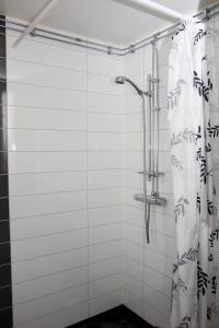 a bathroom with a shower with a shower curtain at Gålö Havsbad - Holiday Cottages and Hostel in Gålö