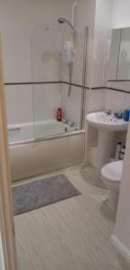 a bathroom with a tub and a toilet and a sink at Lynn's Liverpool Apartment in Liverpool