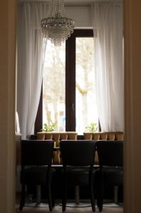 une table à manger avec des chaises et un lustre dans l'établissement Lazarus Hotel & Restaurant, à Lüdenscheid