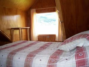 a bedroom with a large bed with a window at Lodge de Montaña Lago Monreal in El Blanco