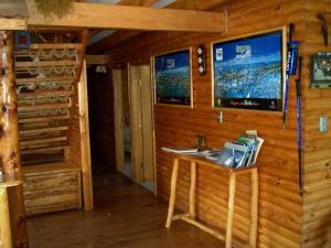Lodge de Montaña Lago Monreal في إل بلانكو: كابينة بها مكتب وتلفزيون على الحائط