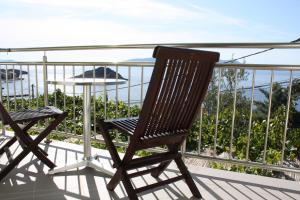 a rocking chair on a balcony with a view of the ocean at Apartments Lidija in Sveti Juraj