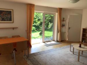 een woonkamer met een tafel en een glazen schuifdeur bij Ferienwohnung im Westallgäu in Gestratz