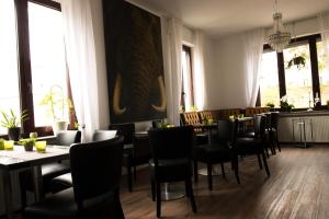 un restaurant avec des chaises, des tables et des fenêtres noires dans l'établissement Lazarus Hotel & Restaurant, à Lüdenscheid
