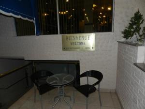a table and two chairs and a sign on a wall at L'Auberge de l'Aeroport Inn in Dorval